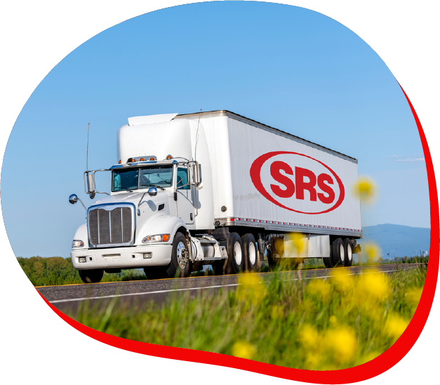 Truck with SRS branding on the side driving on a highway with yellow flowers in the foreground.