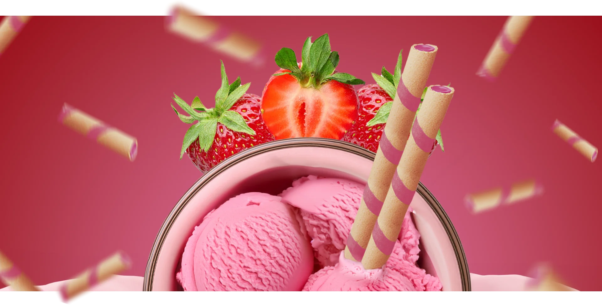 Close-up of a bowl of pink strawberry ice cream garnished with fresh strawberries and wafer roll sticks.